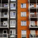Detailed view of a modern apartment building's exterior with balconies and glass windows.