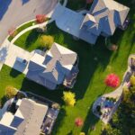 A picturesque aerial view showcasing suburban homes with vibrant gardens and tree-lined streets.